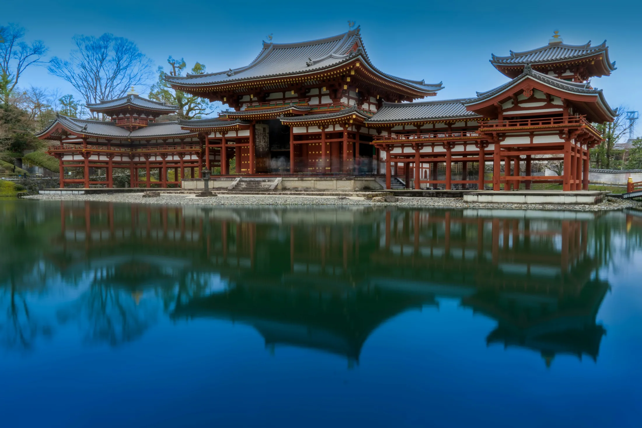 A Japanese temple reflected in still blue water